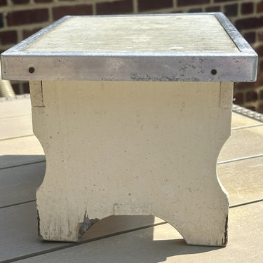 Hocker - cremefarbenes Holz mit Metallkante