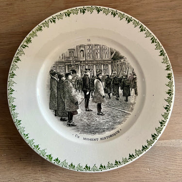Sierbord / Dessertbord - Societe Ceramique Maestricht - décor met rand van groene bladeren en een opdruk met soldaten en de tekst "Un Moment Historique"