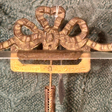 Picture frame/photo frame marked with Paris - with a bow at the top and thick glass with a ground edge - fairly weathered metals, brass?, standard with ball feet and bow.