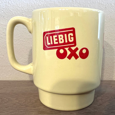 Soepbeker / Mok - ongemerkt - opschrift OXO en Liebig in rode letters op pastelgele achtergrond