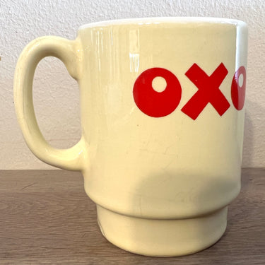 Soepbeker / Mok - ongemerkt - opschrift OXO in rode letters op pastelgele achtergrond