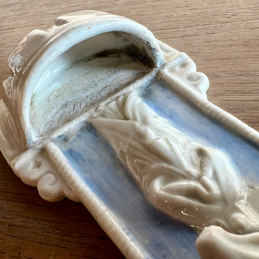 Wijwaterbak met beeltenis onder een afdak