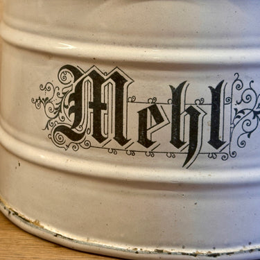 Storage jar - made of white enamel with a light wooden lid and the inscription MEHL (flour) in black letters