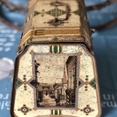 Dose mit schwarz-weißen Abbildungen von Kindern in Tracht.