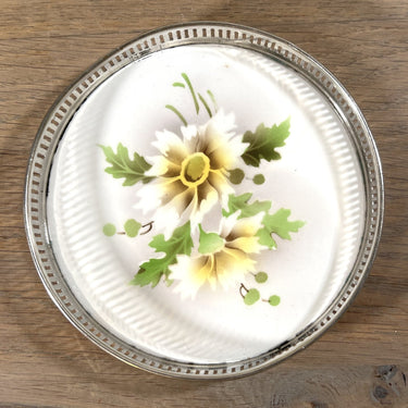 Onderzetter voor glas of fles - chrome omranding - décor in spritzmuster met wit/geel/bruine bloemen
