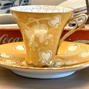 Kopje en schoteltje - klein model van fijn porselein - oranje ondergrond