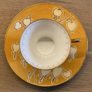 Kopje en schoteltje - klein model van fijn porselein - oranje ondergrond